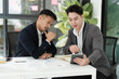 © SOMKID - Two colleagues asian businessman working together to business finance trading at office desk.