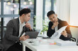 © SOMKID - Two colleagues asian businessman working together to business finance trading at office desk.