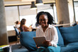 © JustLife - Beautiful African businesswoman in office. Young woman using digital tablet.