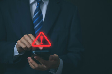 Wall Mural - businessman using laptop showing warning triangle and exclamation sign icon warning of dangerous pro