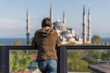 © Travel 'n' Lifestyle - View of a person looking at Sultanahmet Camii (the Blue Mosque) in Sultanahmet district along the Bosphorus strait, European side of Istanbul, Turkey.