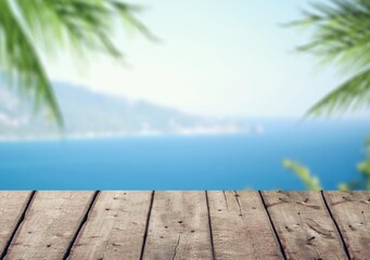 Poster - Empty wood desk over sea and palm leaves