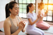 © Somkiat - Asian women exercising in yoga fitness studio.