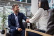 © ReeldealHD images - Businessman shaking hands with businesswoman in a corporate office