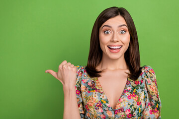 Wall Mural - photo of impressed lovely lady indicate thumb finger empty space offer isolated on green color backg