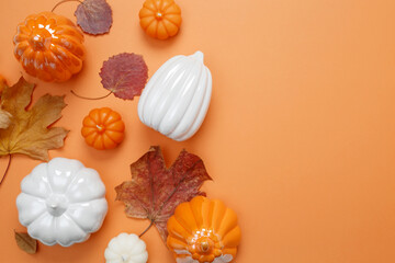 Wall Mural - Set of ceramic pumpkins and candles on orange background. Fall decor, interior decoration. Flat lay, top view, copy space