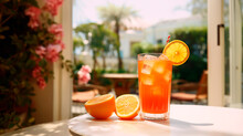 Orange summer cocktail drink with ice in original glass with fresh oranges on the table in Italian garden.