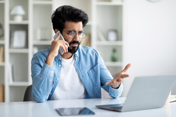 Worried Indian Male Entrepreneur Having Problems With Laptop Computer At Work