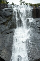 Sticker - the waterfall is close to a large rock in the woods