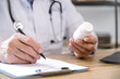 © brizmaker - physician with medication in hand writing medical prescription