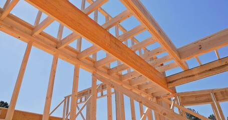 Canvas Print - House with wooden framework frame is being constructed with support beams during construction process