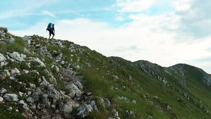 Sticker - Scenic view of a traveller hiking in the rocky mountains on a sunny day