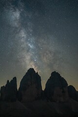 Canvas Print - Scenic star-filled sky view with the Dolomites mountains silhouetted against it