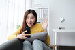© PaeGAG - Young asian woman using smart phone at home. Smiling female making video call meeting smartphone at house.