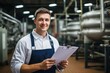 © sirisakboakaew - Inside the food processing factory with a positive smiling technologist holding checklist Industrial workers are satisfied with the results and quality control.