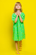© Andrii Iemelianenko - Please, God help. Blonde child girl kid praying, looking at camera making wish asking with hopeful imploring expression begging apology. Little preteen children isolated on yellow background. Vertical