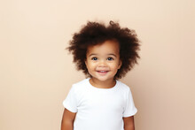 Design Mockup: Cute Black Baby Girl Wearing White Blank Shirt Or Bodysuit On A Pastel Brown Background, Studio Shot