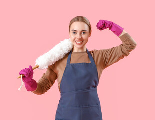 Wall Mural - Young woman with pp-duster showing muscles on pink background