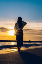 Back View Of Woman Standing On Beach During Sunset