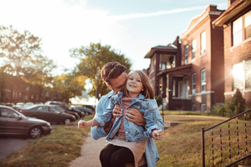 Wall Mural - Father and daughter hugging on a sidewalk in the suburbs of a city