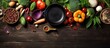 Clean eating food featuring a variety of organic vegetable ingredients, accompanied by an empty iron cooking pot, wooden bowls, and spoons on a wooden background. This top view composition offers
