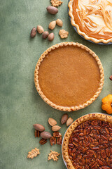 Wall Mural - Variety of traditional Thanksgiving pies on green background with copy space