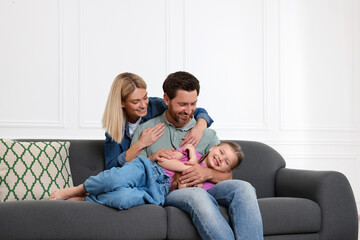 Canvas Print - Happy family having fun together on sofa at home