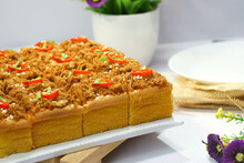 Beef Floss Sponge Cake With A Sprinkling Of Sesame, Green Onions, And Pieces Of Red Chili On A White Plate.