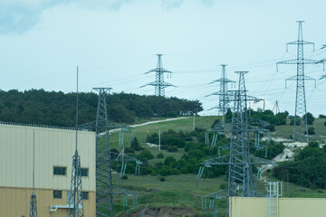 High voltage towers with sky background. Power line support with wires for electricity transmission. High voltage grid tower with wire cable at distribution station. Energy industry, energy saving