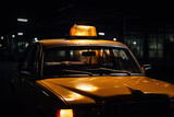 Fototapeta Sawanna - A rainy night in a dark parking with a yellow vintage taxi cab.