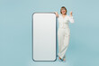 © ViDi Studio - Full body employee business woman 50s wearing white classic suit formal clothes big huge blank screen mobile cell phone do winner gesture isolated on plain blue background Achievement career concept