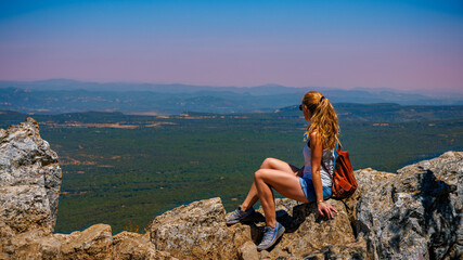 Wall Mural - Woman sitting on mountain peak enjoying panoramic view of France landscape- hiking, adventure, travel concept