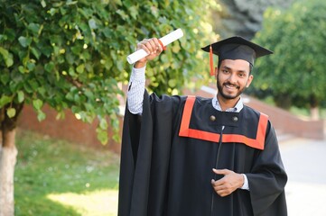 Wall Mural - Handsome indian graduate in graduation glow with diploma.