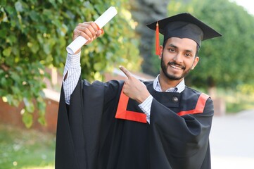 Wall Mural - Handsome indian graduate in graduation glow with diploma.