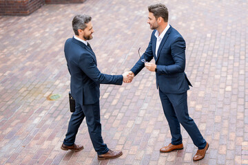 Business team. Businessman handshake with partner. Businessmen in suit shaking hands outdoors. Handshake between two businessmen. wo business men had business contacts. Business men have a meeting.