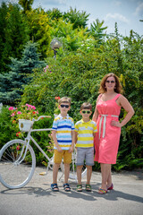 Portrait of happy family mother and two boys near bicycle with f