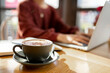 © Austockphoto - coffee on table of person working remotely on her laptop at a cafe
