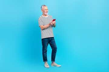 Sticker - Full length photo of positive retired man wear stylish striped clothes look empty spae sale device shop isolated on blue color background