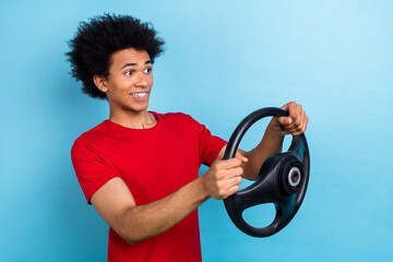 Canvas Print - Profile photo of puzzled worried young man biting lips hands hold wheel look empty space isolated on blue color background