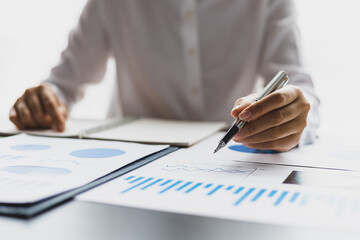 Businesswoman working on documents analyzing business finance charts and planning investments.