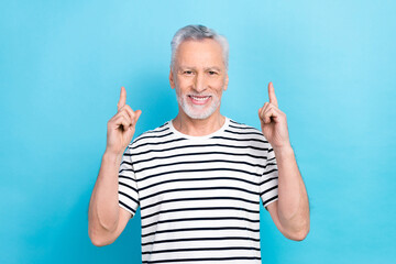 Sticker - Photo of senior aged man promoter directing fingers up empty space advertising hospital clinic isolated blue color background