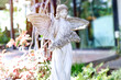 statue of a marble winged angel adorns the garden,Roman style female statue in the park.