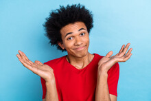 Photo Of Confused Funny Guilty Guy With Afro Hairstyle Dressed Red Stylish T-shirt Shrugging Shoulders Isolated On Blue Color Background