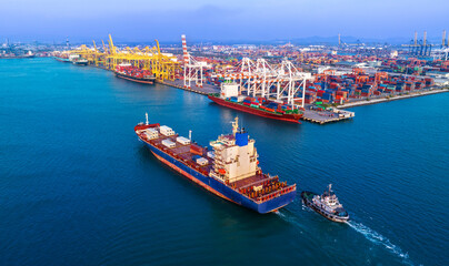 Large cargo ships are docked at a large export warehouse in an industrial zone.