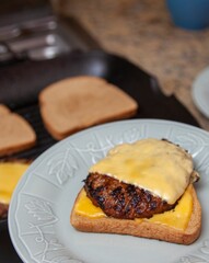 Sticker - a plate topped with a burger covered in cheese and meat