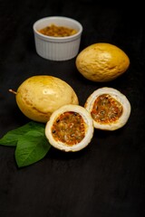 Sticker - White ceramic bowl filled to the brim with passion fruit on black surface