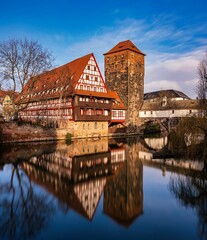 Wall Mural - Vertical shot of a historic tower in Nuremberg, Germany, with reflection mirrored in the water below