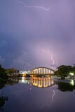 Fototapeta  - Vertical shot of lightning striking over the illuminated Bridge of the Plaza Rio San Juan
