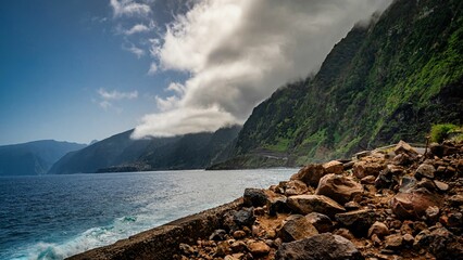 Poster - a scenic area with rocks, water, and mountains in the background