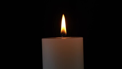 Wall Mural - person lighting a candle with a match on the empty black background